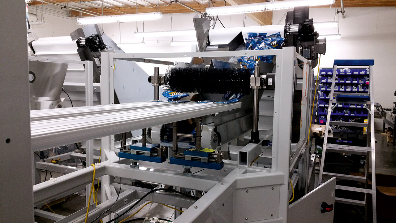 東興為企業度身訂製自動化生產系統，圖為東興為一薯片生產商設計的自動包裝機。