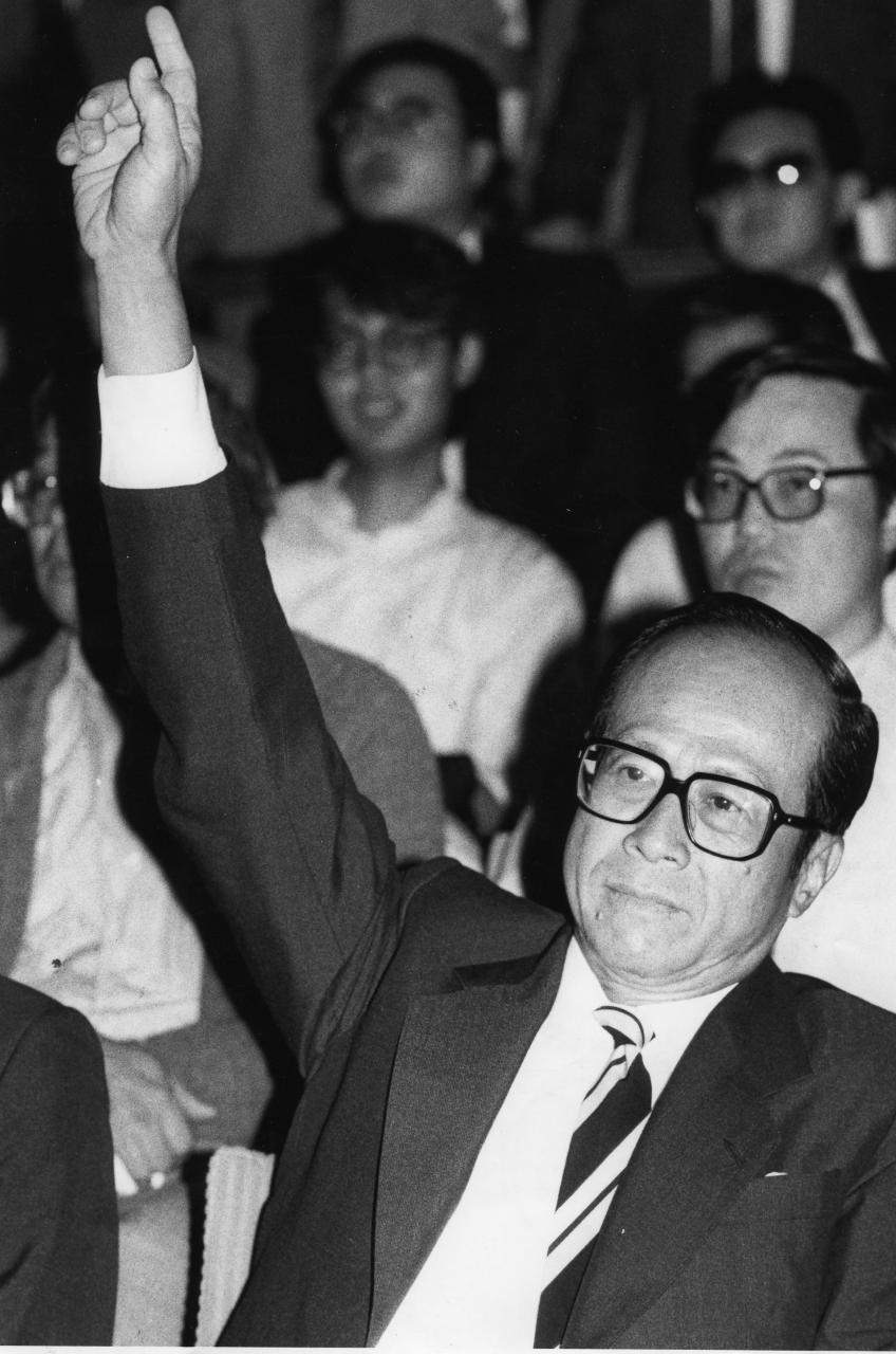1958年，李嘉誠意識到香港土地求過於供，開始涉足地產業。圖為八十年代一次土地競投時，他出價時的招牌手勢。